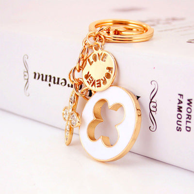 goldene clover schlüsselanhänger – verspieltes blütendesign mit strass - lunastein