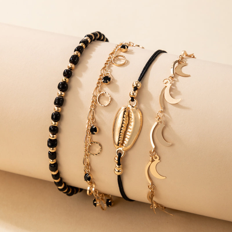 luna coast – 4-teiliges fußkettchen-set in gold & schwarz - lunastein - schmuck